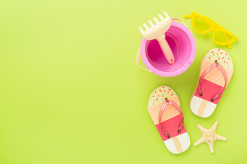 Children's flip flops and beach toys on color background,,top view