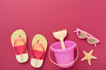 Children's flip flops and beach toys on color background,,top view