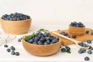 Bowl with fresh blueberries on wooden table