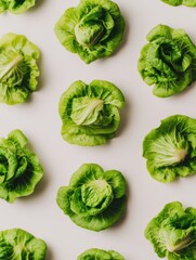 Obraz premium Fresh Green Lettuce Leaves Arranged Aesthetically on Light Background for Healthy Eating and Culinary Use