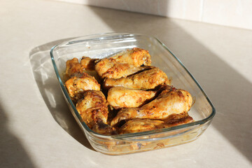 close up of home style crispy roasted chicken legs drumsticks in garlic mayo sauce in a transparent...