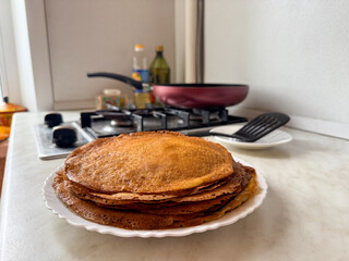 Freshly cooked pancakes on a kitchen counter with cooking utensils