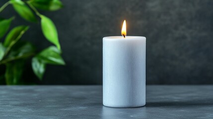 Simple white candle on dark surface