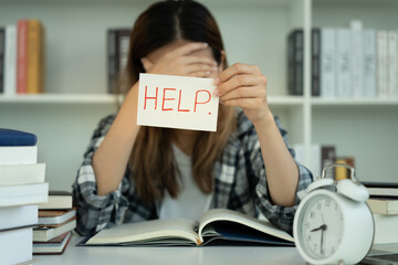 Asian student woman have anxiety because of exams, female hold help in the library. stress,...