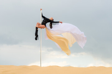 Athletic Dancer with Flowing Fabric on Pole in Sandy Landscape — Dramatic Sky Background with Copy Space