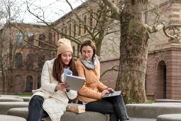 Students collaborate with laptops and books in a tranquil University Park