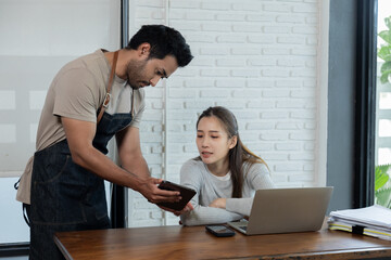 Beautiful female customer ordering food with waiter in restaurant. Indian male waiter taking orders from customers and Offer food recommen or new menu of shop. Restaurant small business owner concept.