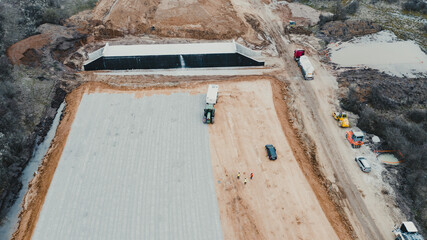 Construction site with tractor leveling ground and workers supervising