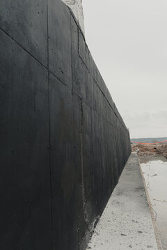 Waterproofing concrete wall: applying bituminous coating for foundation protection