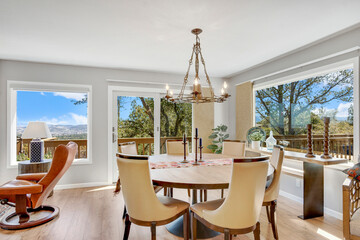 A dining room with a table, chairs, and an elegant chandelier