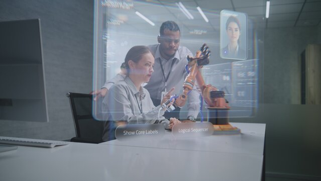 Futuristic Office: Two Diverse Engineers Working on Advanced Robotic Arm Using Augmented Reality Technology. Holographic Interface Display with AI Assistant and Data Analysis. High-Tech Innovation.