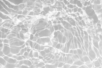 White water with ripples on the surface. Defocus blurred transparent white colored clear calm water surface texture with splashes and bubbles. Water waves with shining pattern texture background.