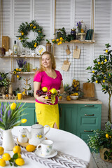 A cheerful blonde is relaxing in the kitchen. Scandinavian cuisine in green tones, beautiful female housekeeper