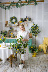 A cheerful blonde is relaxing in the kitchen. Scandinavian cuisine in green tones, beautiful female housekeeper