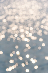 Circular light spots on the water surface. The river in bokeh. Dreamy blue background.