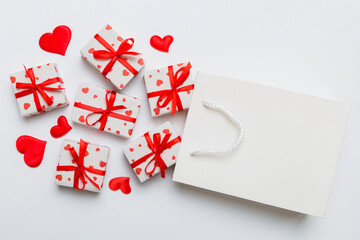 Fototapeta na wymiar Gift boxes pop out from paper bag top view on colored background. bag packing handmade boxes fall out Concept of holidays, shopping, sale, discounts. Top view, flat lay