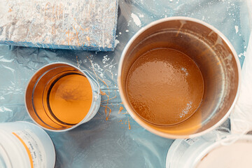 Construction workers preparing epoxy resin for floor finishing