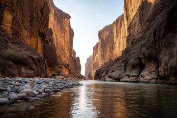 River Flows Through Canyon with High Rock Walls and Pebbles