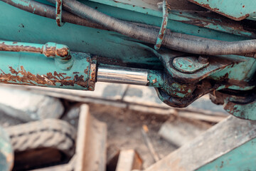 Rusty hydraulic cylinder of excavator showing premature wear and tear