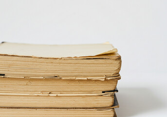 vintage books stacked on each other against a plain background -  