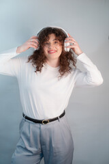 Naklejka premium Woman in wireless headphones dances and sings, enjoying music as a way of healing and joy.