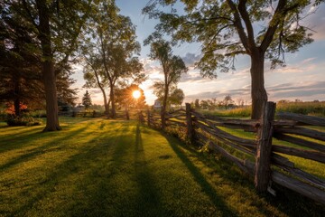 Sunset Over Green Field with Wooden Fence and Trees Scenery