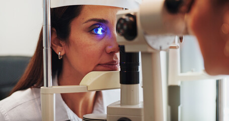 Eye test, optometry or optician with woman in clinic with diagnostic tool for prescription lens. Ophthalmology, laser or optometrist in vision assessment with person, machine or medical equipment