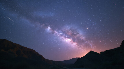 A view of the milky way and a shooting star over the mountains in the dark night sky landscape