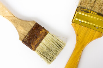 Still life of two old decorating paint brushes, isolated on white background.