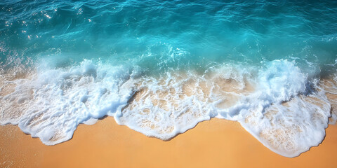 Clear turquoise waves wash ashore, creating foam on a sandy beach in bright sunlight