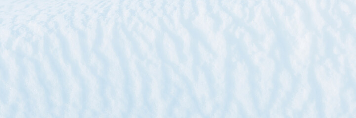 Obraz premium Wide panoramic winter background with snowy ground. Natural snow texture. Wind sculpted patterns on snow surface.