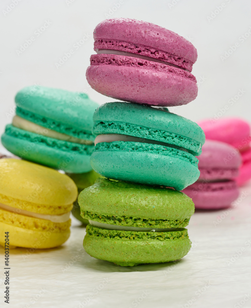 Poster an assortment of colorful macarons on a white surface. the macarons have a smooth, delicate shell an