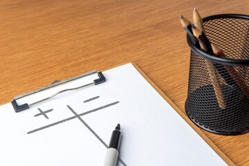 Closeup image of paper clipboard with pros and cons list on wooden table. Assessment, comparison...