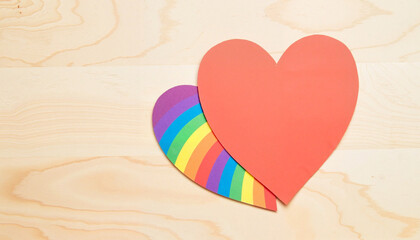 Fototapeta premium Heart Shape Cutout with Rainbow Stripes on Light Wooden Surface for Creative Projects, Pride Campaigns, Stationery Design, and Social Media Content