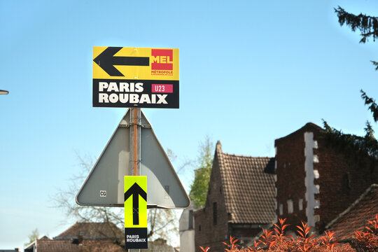 Wallers, France - 04 11 2025 : Directional signs for the Paris-Roubaix U23 cycling race in a quaint European village under a clear blue sky.