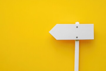 A white wooden signpost indicating direction on yellow background