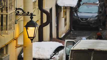 Vintage street lamp illuminating snowy alley in winter