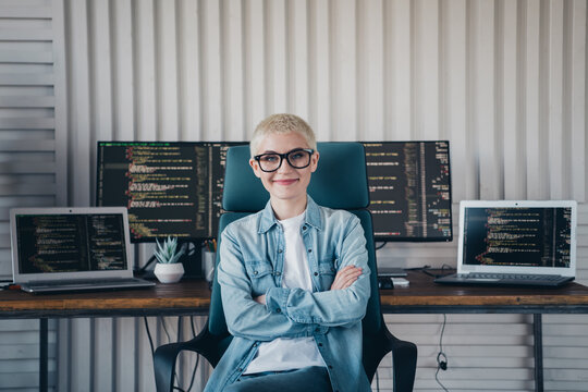 Confident Female IT Professional Posing in a Modern Coding Workspace with Multiple Monitors