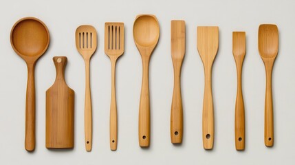 A set of bamboo kitchen utensils such as a spoon, spatula, and ladle arranged neatly on a light-colored surface with ample space for text