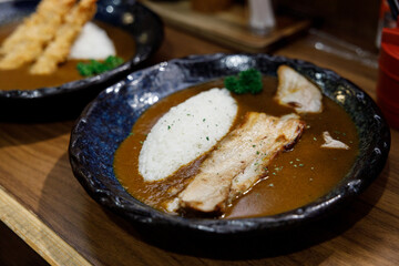 Delicious Japanese style curry rice topped with pork belly on plate. Selective focus.
