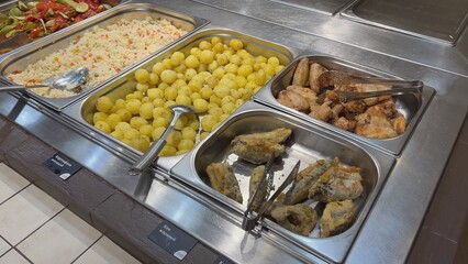 Self-service restaurant offering various dishes including potatoes, rice, chicken and fish