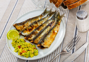 Delicious grilled sardines with guacamole and lemon