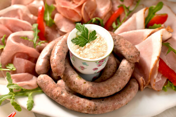 A plate with cold cuts and boiled white sausage with horseradish for Easter