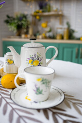a bouquet of flowers on the kitchen table and a teapot with a cup. The concept of home comfort