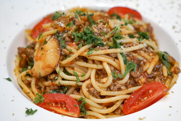 Close up view of a plate of Spaghetti Bolognese, a hearty pasta dish with a rich, meaty tomato sauce, commonly made with beef, onions, garlic, and herbs.