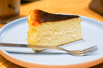 Delicious Slice of Cheesecake on a Blue Plate with a Metal Fork