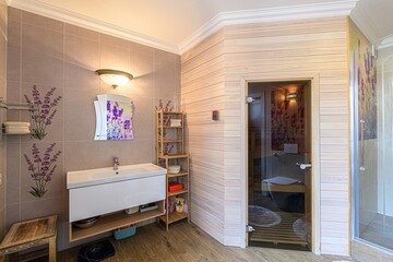 modern bathroom with lavender decor, a white sink, wooden shelves, and a sauna.
