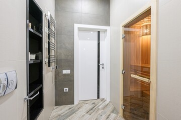 modern bathroom with a sauna, featuring sleek design elements like wood-look tiles, a minimalist...