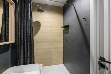 Modern bathroom with gray tile, light wood accents, and a sleek, minimalist design. Bright and...