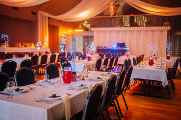 Banquet hall decorated for VU 20 anniversary celebration with festive dining tables, elegant lighting, drinks, and cozy atmosphere..